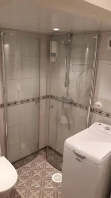 a small bathroom with a shower and a toilet at Trivelig Stabbur på Lånke Gård