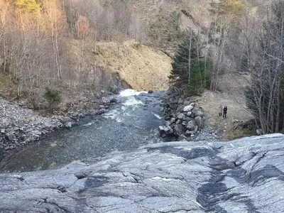 two people walking along a river with rocks at Feriehus Rodal med Båt in Rodal