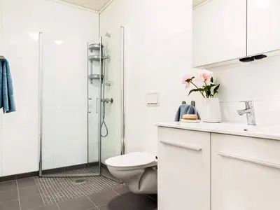 a white bathroom with a toilet and a shower at 8 person holiday home in Sandøy in Finnøy