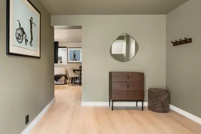 a living room with a dresser and a mirror at Trolltunga Fjord Stay in Odda