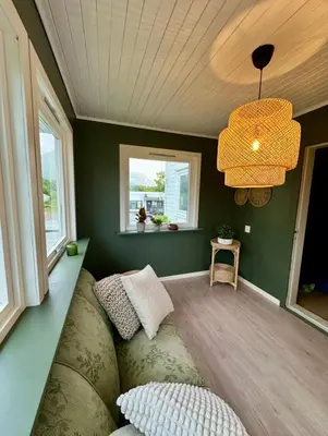 a living room with a couch and a chandelier at Spacious holiday home by the fjord and mountains in Sæbø