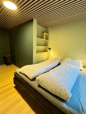 a bedroom with a bed with a wooden floor at Spacious holiday home by the fjord and mountains in Sæbø