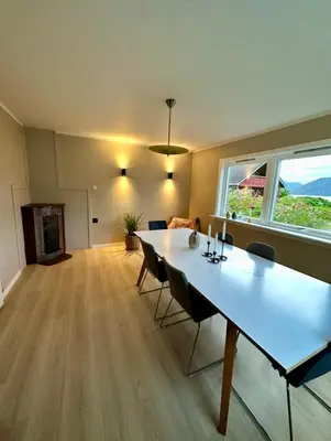 a living room with a large white table and chairs at Spacious holiday home by the fjord and mountains in Sæbø