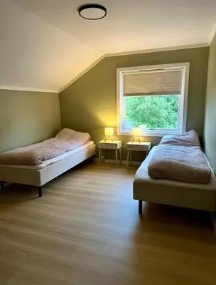 a bedroom with two beds and a window at Spacious holiday home by the fjord and mountains in Sæbø