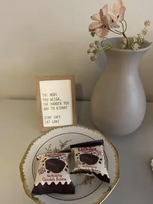 a plate with two pieces of cake and a vase at Bright & Spacious Apartment by the Sea, Free Parking, 10min to Airport, 12min to Ålesund in Ytterland