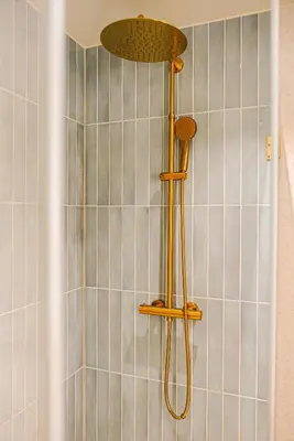 a shower with a shower head in a bathroom at Apartment in the heart of Ålesund city in Ålesund