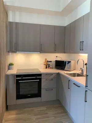 a kitchen with white cabinets and a black oven at New and modern apartment in Trondheim, Øvre Nyhavna in Trondheim