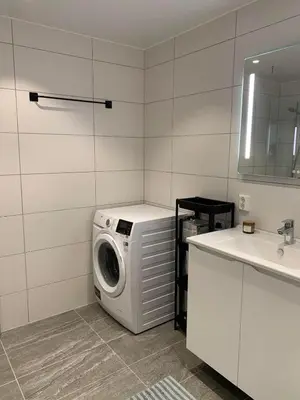 a washing machine in a bathroom next to a sink at New and modern apartment in Trondheim, Øvre Nyhavna in Trondheim