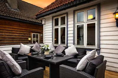 a patio with a table and chairs on a house at Central stay apartment - 201 in Bergen