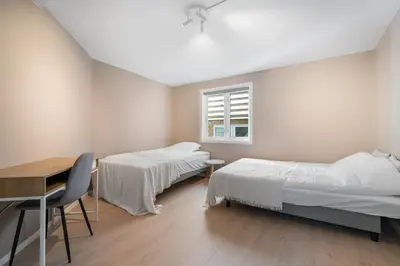 a bedroom with two beds and a desk and a window at Central stay apartment - 201 in Bergen