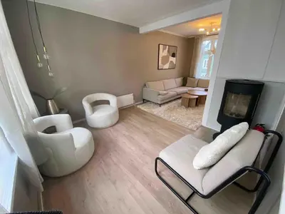 a living room with white furniture and a tv at Historic House City Centre in Bergen