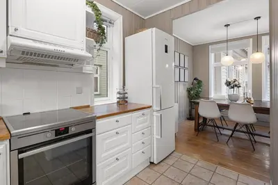 a kitchen with white appliances and a dining room at Historic House City Centre in Bergen