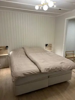 a bed in a bedroom with a white wall at Historic House City Centre in Bergen