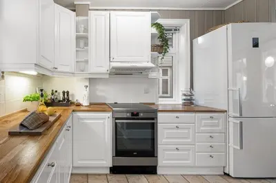 a white kitchen with a stove and white cabinets at Historic House City Centre in Bergen