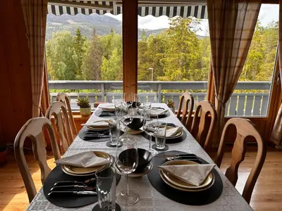a table with plates and glasses on a table with a view at Family house near Kvitfjell & Hunderfossen in Fåvang