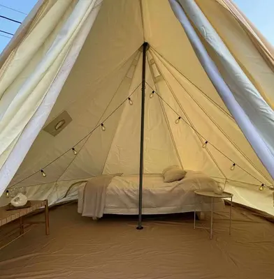 a tent with a bed in the middle of it at Ocean Glamping