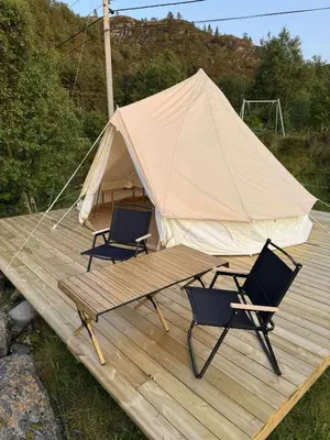 two chairs and a tent on a wooden deck at Ocean Glamping