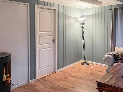 a living room with a door and a lamp at 8 person holiday home in hauglandshella