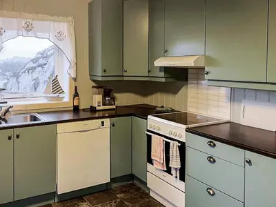 a kitchen with green cabinets and a sink at 8 person holiday home in hauglandshella