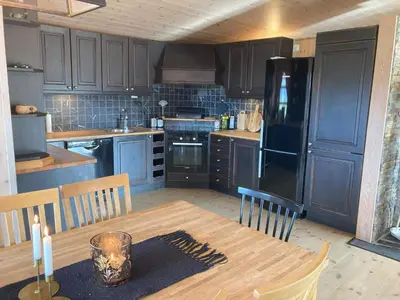 a kitchen with a wooden table and a black refrigerator at 10 person holiday home in NORDTORPA in Nord Torpa
