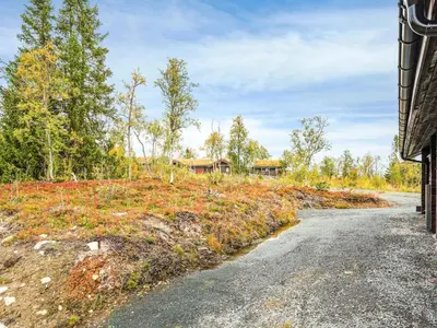 an empty road in a field with houses in the background at 8 person holiday home in Ålen in Ålen