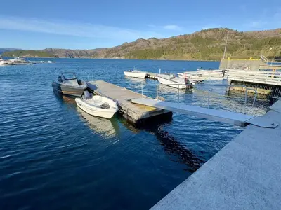 a group of boats docked at a dock in the water at 4 star holiday home in Huglo in Nordhuglo