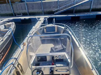 a small boat is docked in the water at 4 star holiday home in Huglo in Nordhuglo