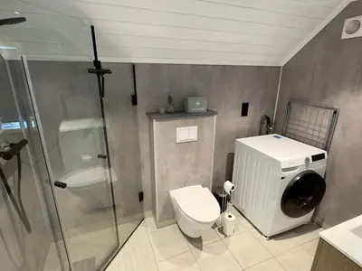 a bathroom with a toilet and a glass shower at 4 star holiday home in Huglo in Nordhuglo