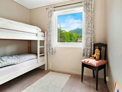 a bedroom with bunk beds and a window with a teddy bear at 8 person holiday home in Stavang in Stavang