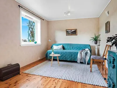 a living room with a blue couch and a window at 8 person holiday home in Stavang in Stavang