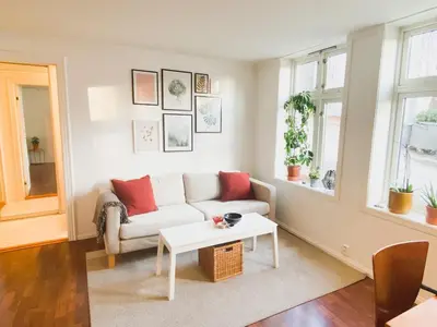 a living room with a couch and a table at Cosy authentic apartment, only 60m from Bryggen! in Bergen