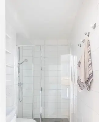 a white bathroom with a shower and a toilet at Modern apartment ONLY 5 minutes from City centre in Bergen