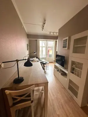 a living room with a desk with a lamp and a television at Koselig bygårdsleilighet i Bergen sentrum in Bergen
