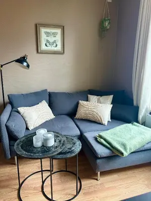 a blue couch in a living room with a table at Koselig bygårdsleilighet i Bergen sentrum in Bergen