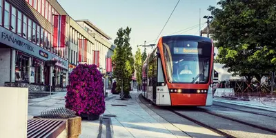 a red and white tram on a city street at Newly Renovated Rom Bergen Fana in Bergen