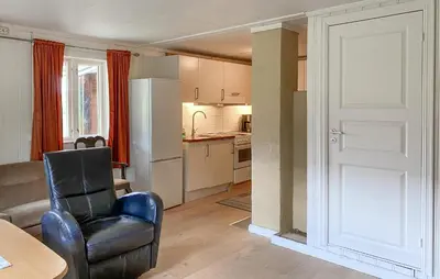 a living room with a chair and a kitchen at Stunning Home In Eidsvåg I Romsdal in Toven