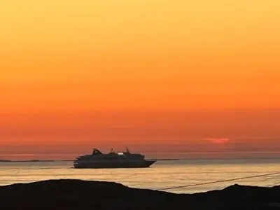 a large boat in the ocean at sunset at Atlantis cabin with sauna and great views in Vevang