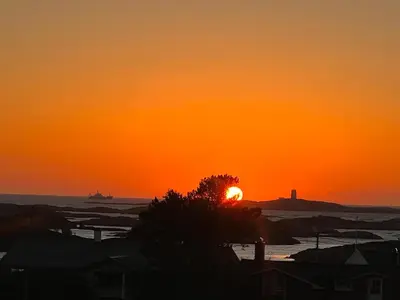 a sunset with the sun setting over the ocean at Atlantis cabin with sauna and great views in Vevang