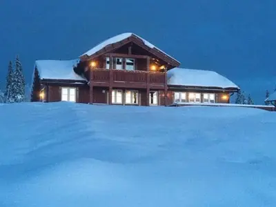 a house covered in snow with a pile of snow at Modern Cabin With Views In Lygna in Jaren