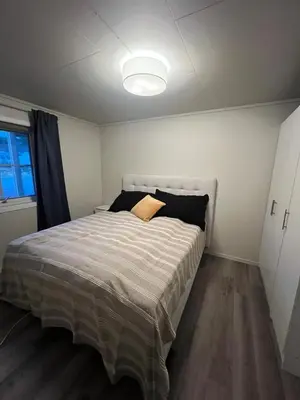 a bedroom with a bed with a light on the ceiling at Furnished apartment near Aker Solutions in Stord
