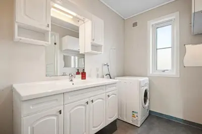 a white bathroom with a sink and a washing machine at Furnished apartment near Aker Solutions in Stord