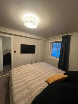 a bedroom with a bed and a flat screen tv at Furnished apartment near Aker Solutions in Stord