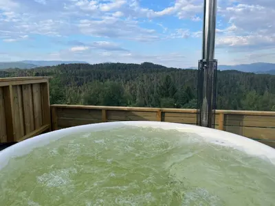 a jacuzzi tub on a balcony with a view at Hyggelig Gård Nær Bergen Med Spabad in Hjelmås