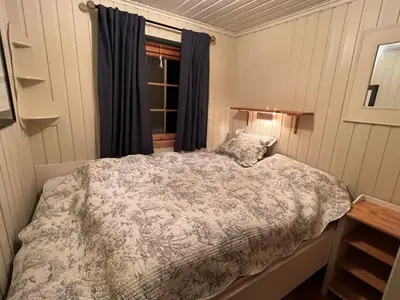 a bedroom with a bed and a window at Koselig, lita hytte på Aurdalsåsen ved Danebu in Aurdal