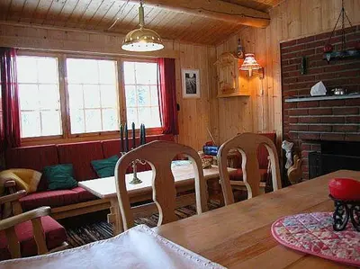 a dining room with a table and chairs and a fireplace at Koselig, lita hytte på Aurdalsåsen ved Danebu in Aurdal