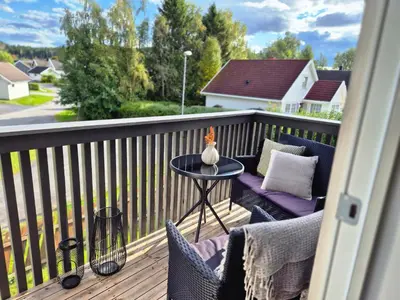 a balcony with a table and chairs on a deck at Trines Hjerterom in Steinkjer