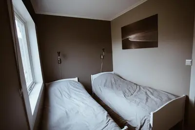 a bedroom with two beds and a window at Beach apartment with unique view in Ervik
