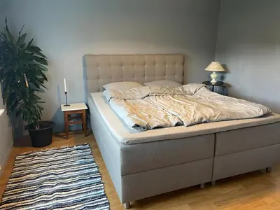 a bed in a bedroom with a lamp and a rug at Location, location, location in Ervik