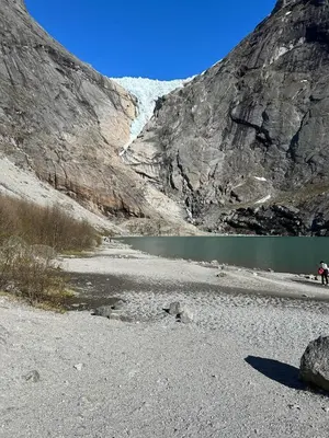 a mountain with a body of water and a glacier at Granli-Apartment in Stryn