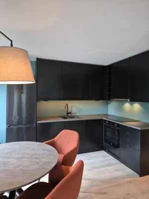 a kitchen with black cabinets and a table and chairs at Granli-Apartment in Stryn
